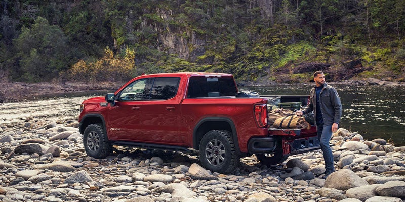 2026 GMC Sierra 1500 Elevation in red parked by a river demonstrating capability and rugged design