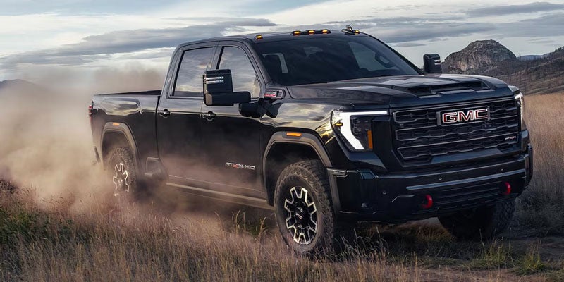 2026 GMC Sierra 3500 HD driving off-road through dust