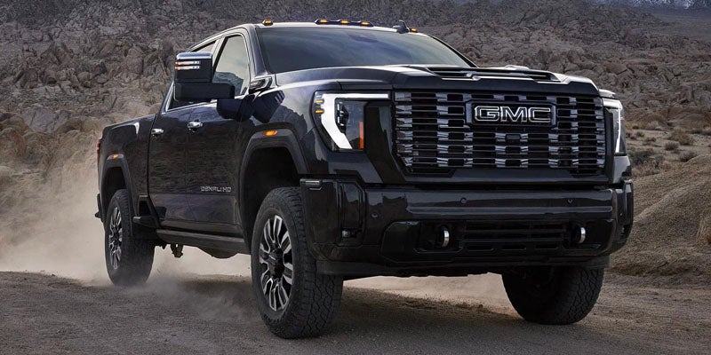 Front three-quarter view of the 2026 GMC Sierra 3500 HD on a dirt road