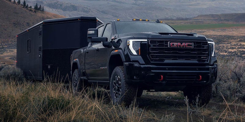 2026 GMC Sierra 3500 HD towing an enclosed trailer outdoors